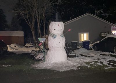 Gathering up all the snow possible to make this larger- than- life snowman on Newberg Dr.